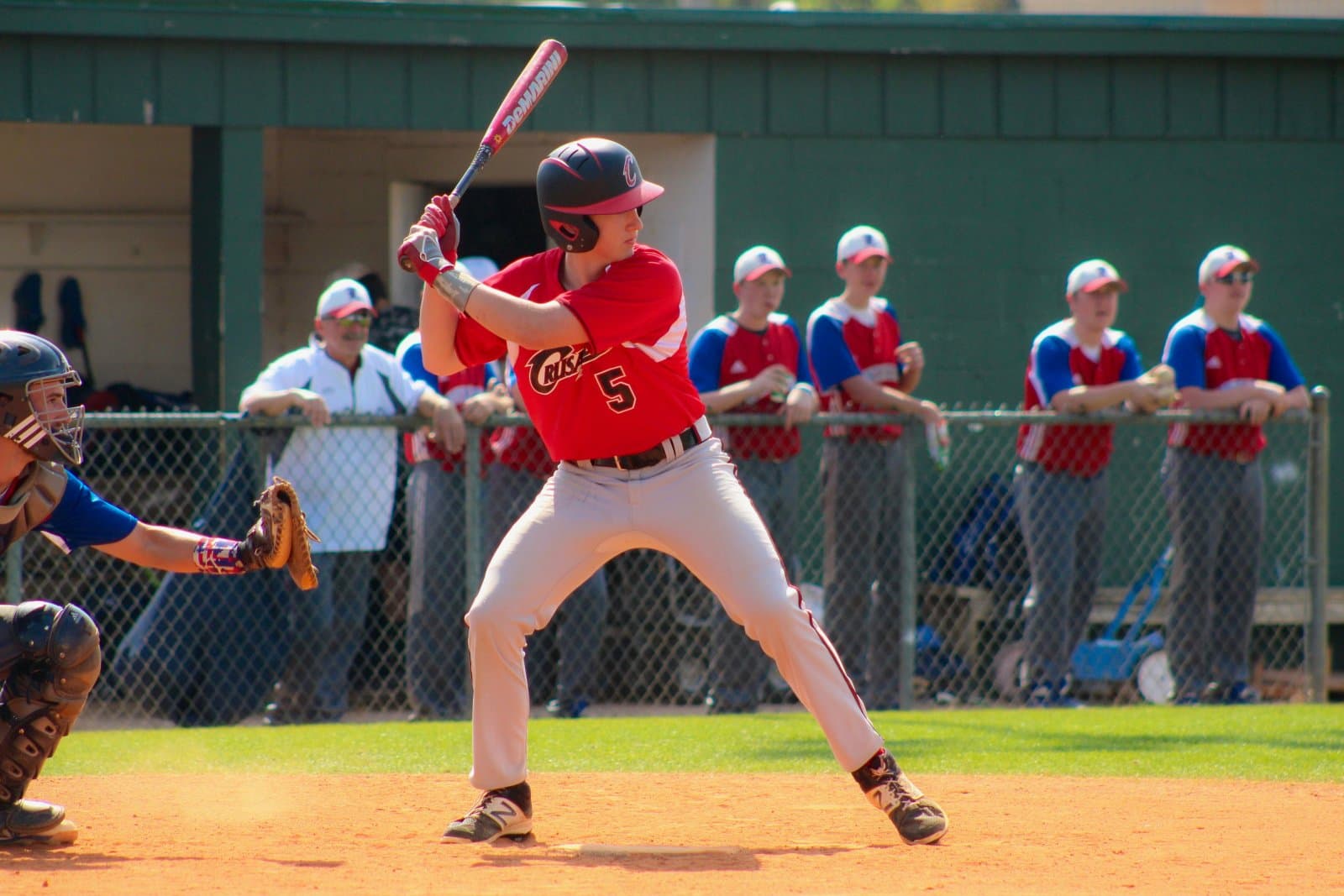 A batter filmed from the side with the whole body, head to feet, in frame